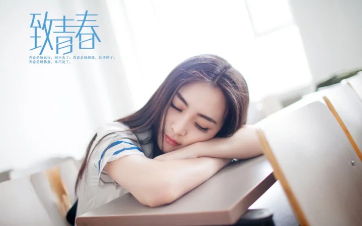 一名女子閉眼伏在桌面上休息，畫面上方有藍色中文字。