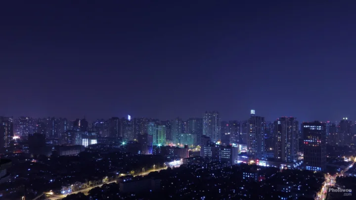 夜の都市のスカイラインが、高層ビルと道路の明かりに照らされています。