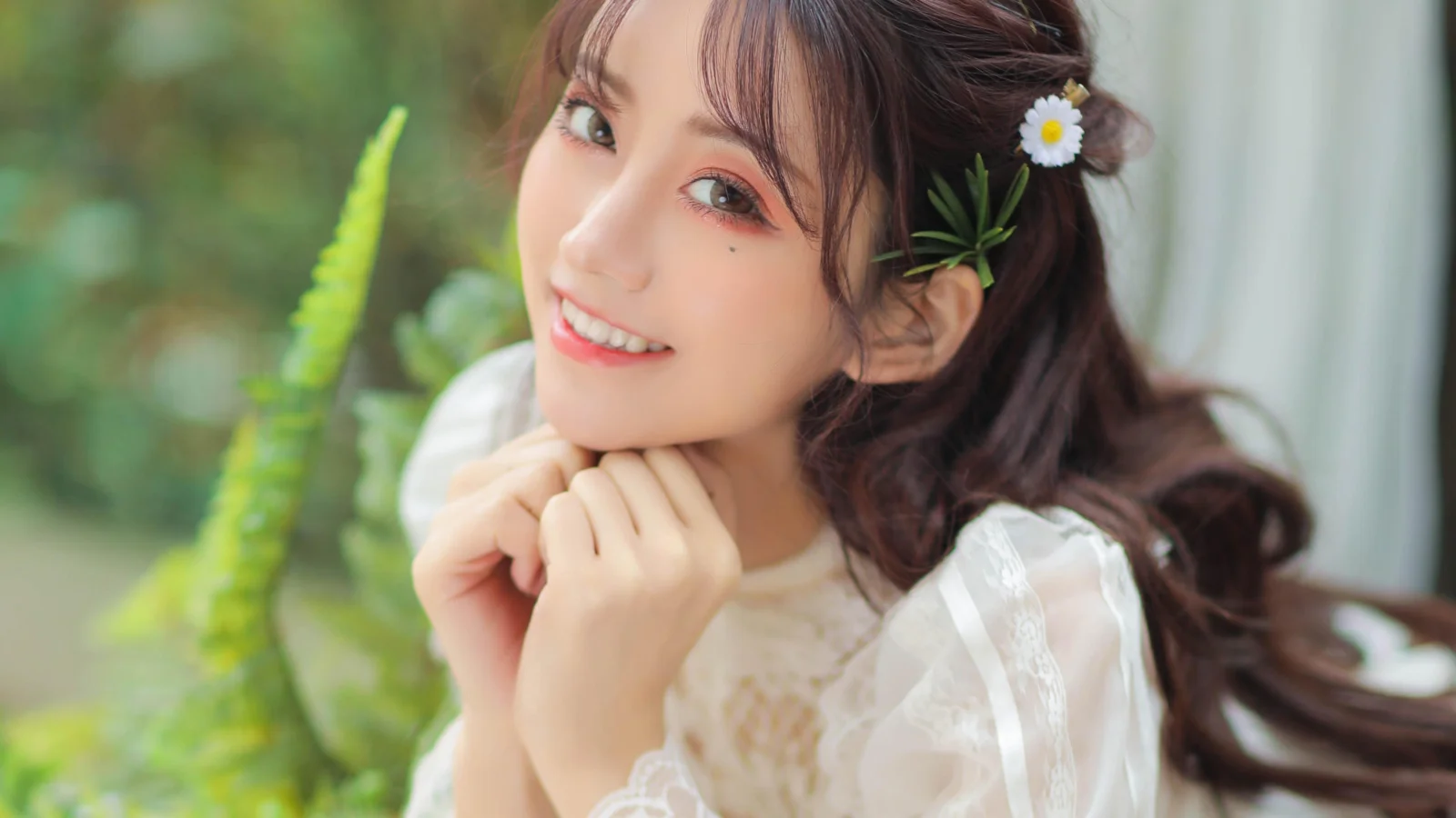 一位成年女性靠在窗边微笑，双手托腮，背景可见绿植。