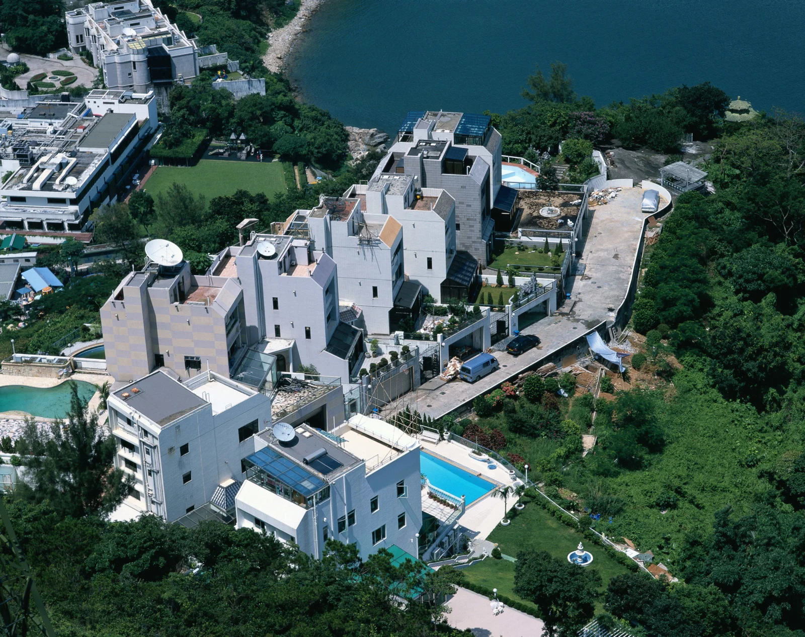 俯瞰湖畔绿地、现代住宅建筑和周围森林的城市景观。