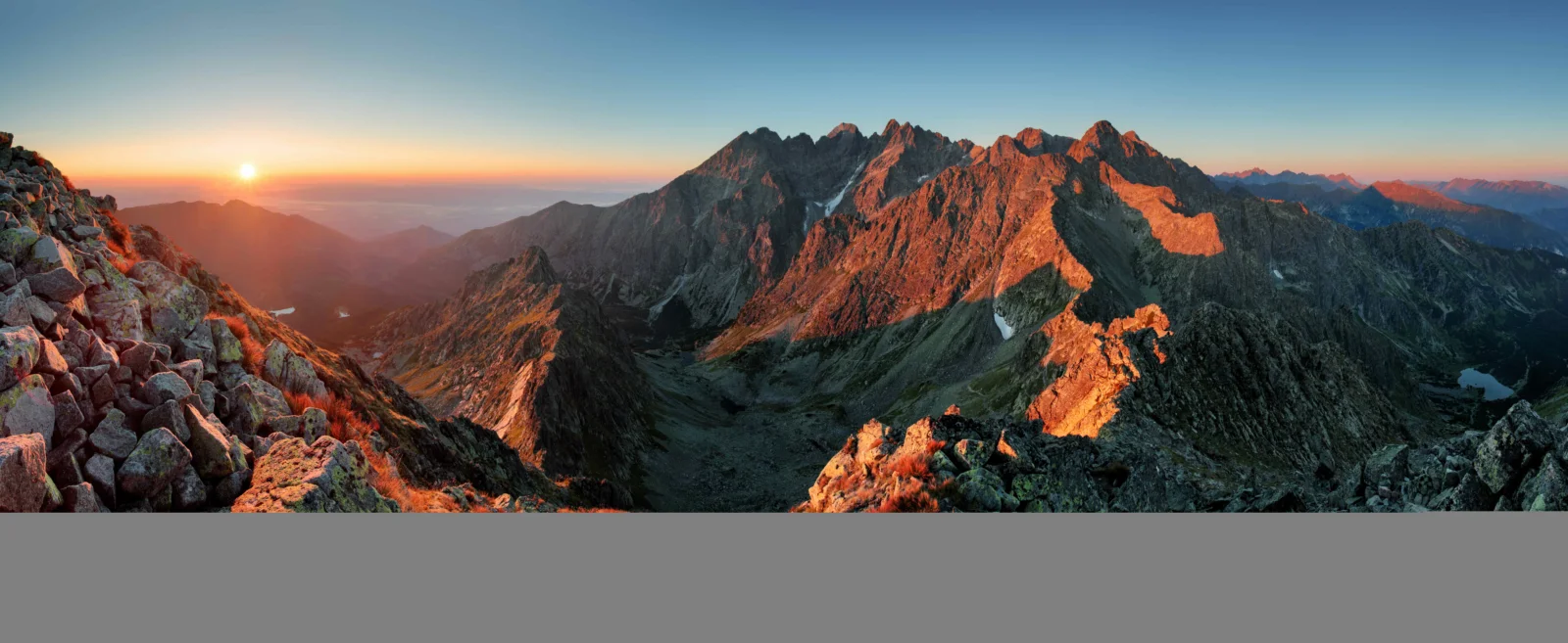 夕陽映照著層疊的嶙峋山峰與山谷，構成壯闊的山地全景。