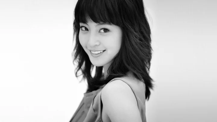 一位成年女性以黑白风格面对镜头微笑。