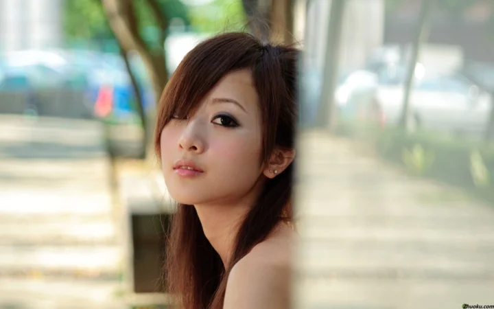 一名成年女性靠在窗边，阳光从背景和玻璃间洒入，形成柔和的人像画面。