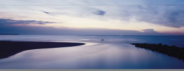 暮色天空下，宁静海湾与沙滩延伸至远方海面。