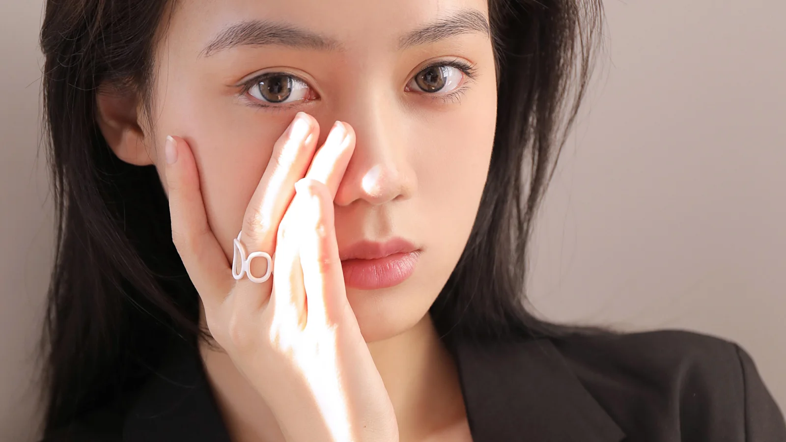 一名成年女性以手触脸的面部特写肖像。
