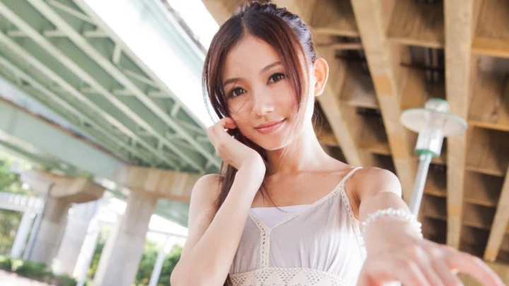 一名成年女子在桥下户外环境中微笑注视镜头。