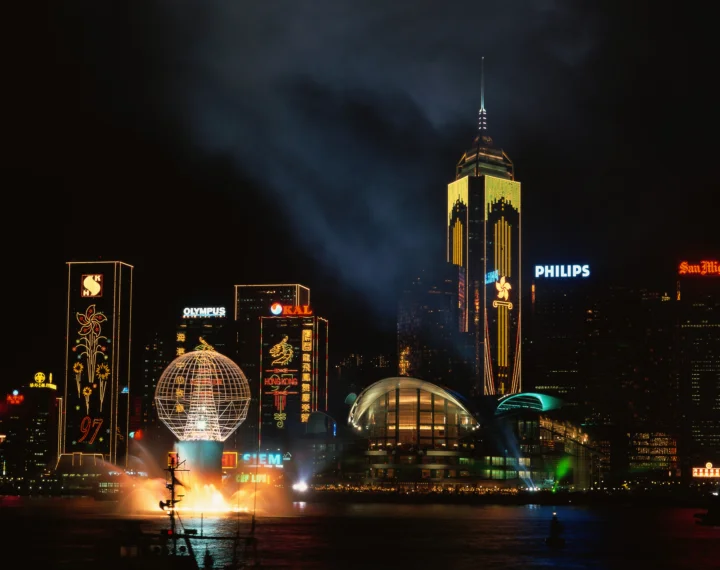夜色中的城市天际线被高楼灯光照亮，水面映出斑斓倒影。