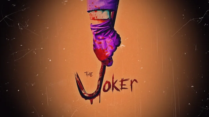 橙色背景中央悬挂着一只紫色手套，并配有“The Joker”手写字样。