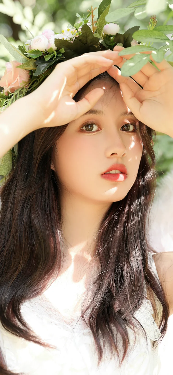 一名長髮女子在花葉間抬手遮擋陽光，臉龐沐浴在斑駁光影中。