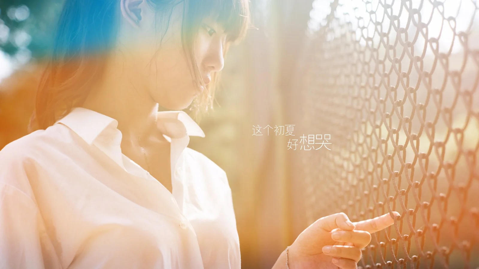 一名穿白色衬衫的女性站在带有格纹装饰的窗边，暖色阳光洒在画面上。