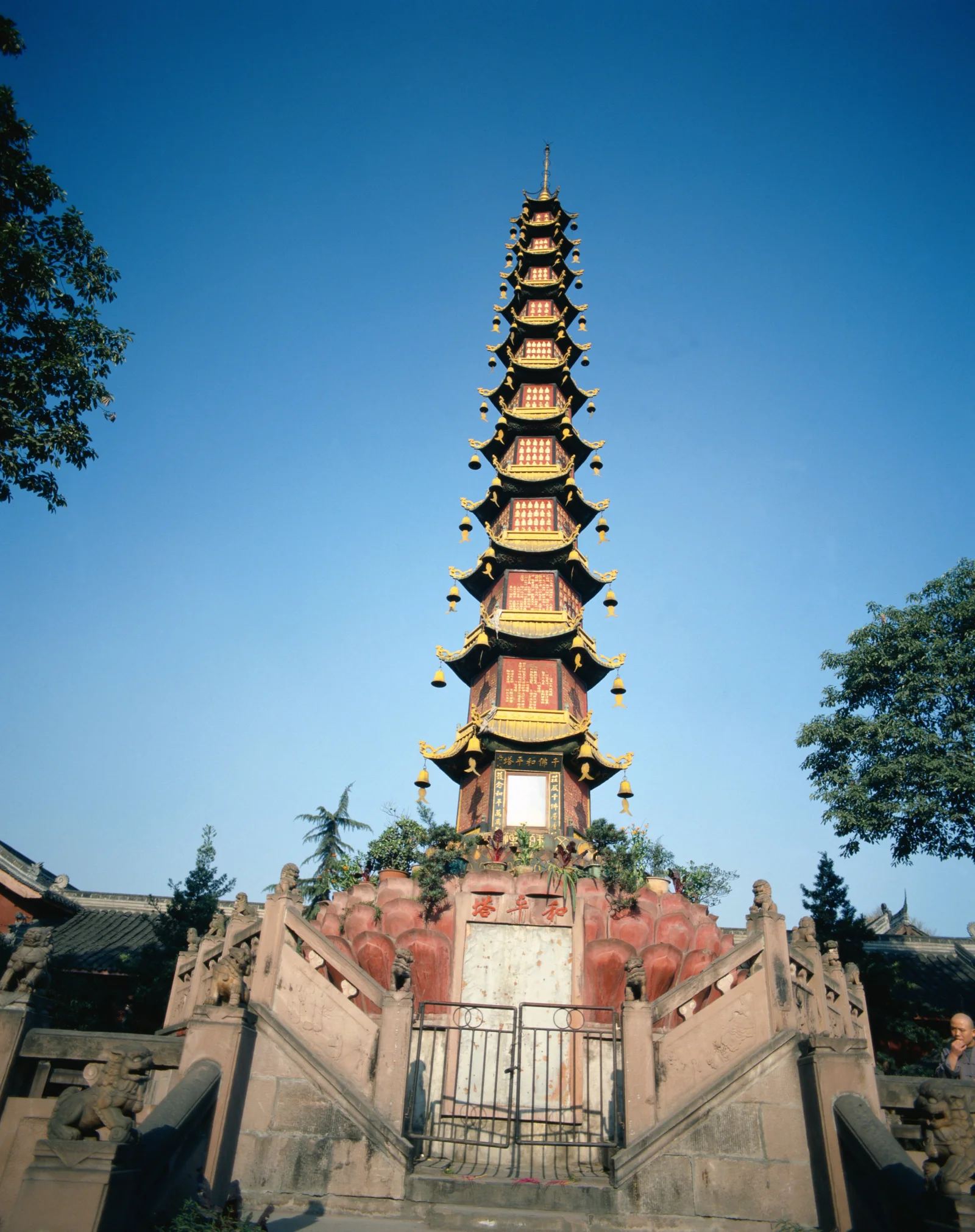 蓝天下，一座装饰华丽的多层古塔矗立在石阶与寺庙建筑之间。