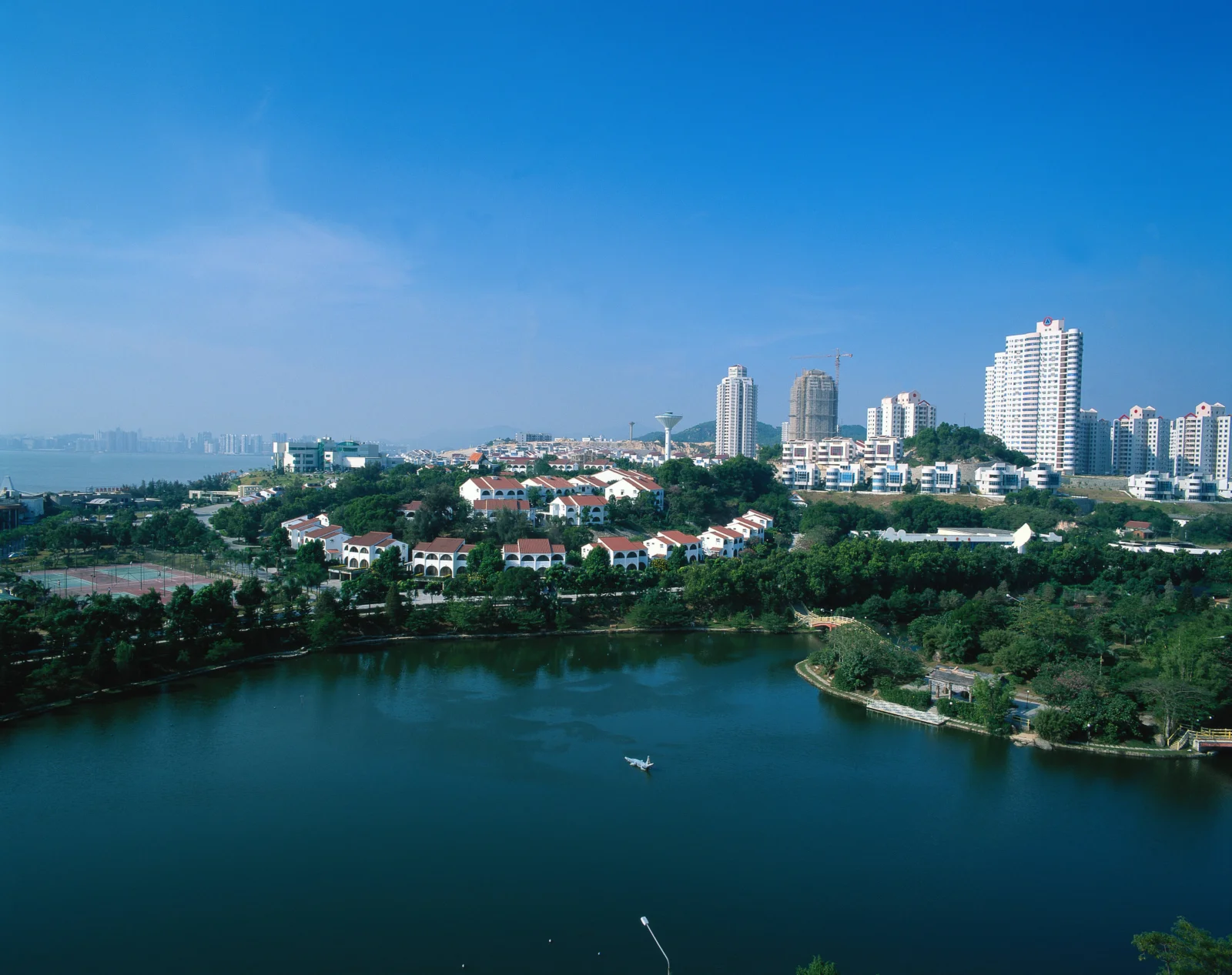 湖泊前方是一片由高层建筑和低层住宅组成的城市天际线。