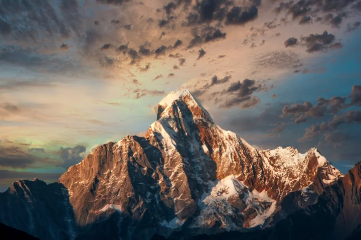 壮丽的雪山在晚霞与层云映衬下展现出鲜明的光影层次。