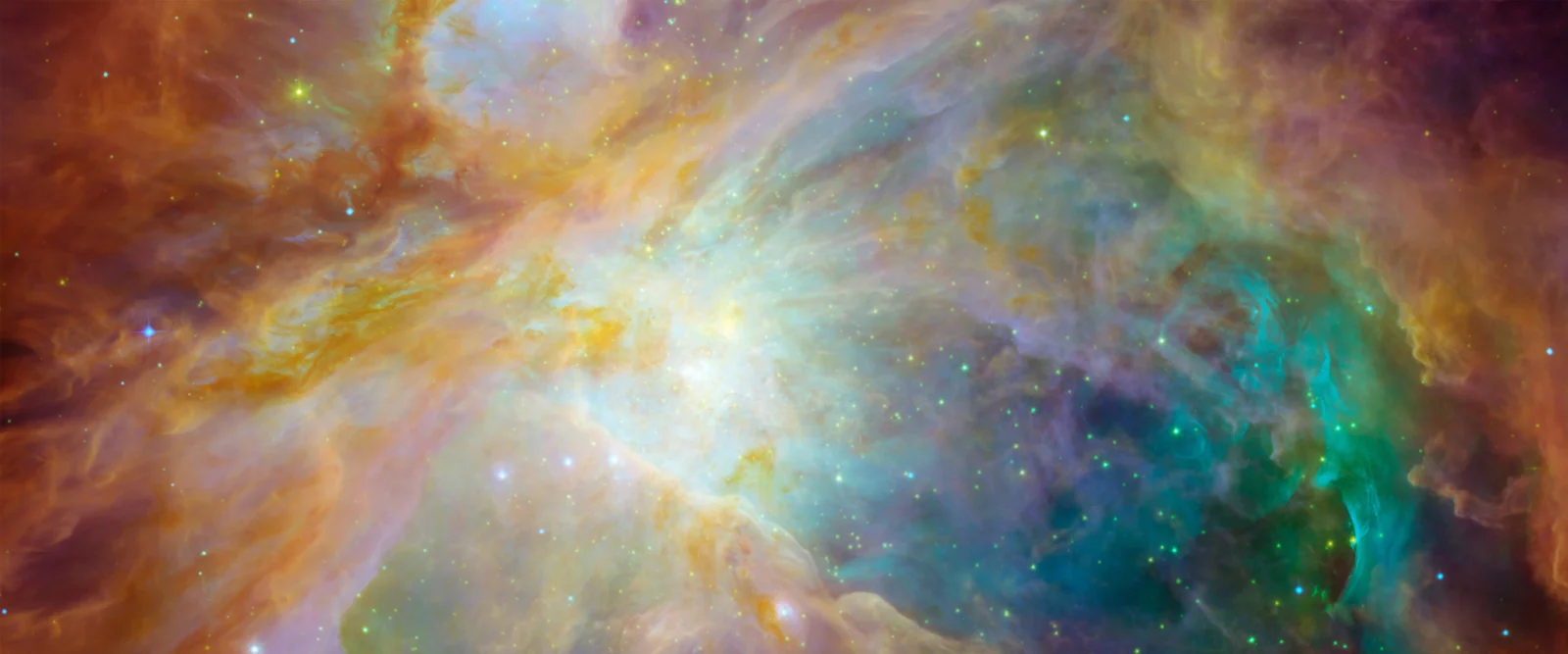 金色や青緑色、紫色の雲が入り混じる鮮やかな星雲に、きらめく星々が散りばめられています。