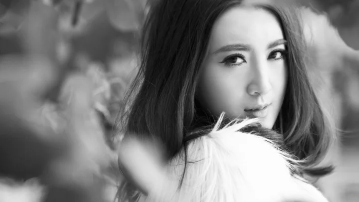 一名成年女性身穿毛绒服饰，以黑白色调面对镜头。