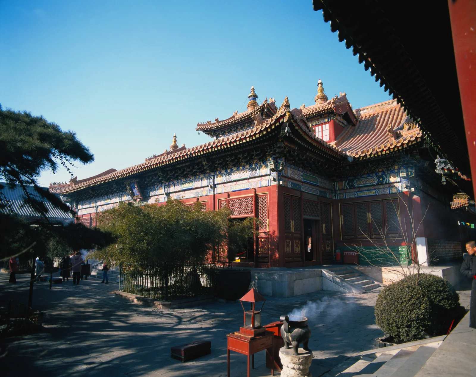 蓝天下，一座红墙金瓦的中国传统古建筑坐落在庭院中。