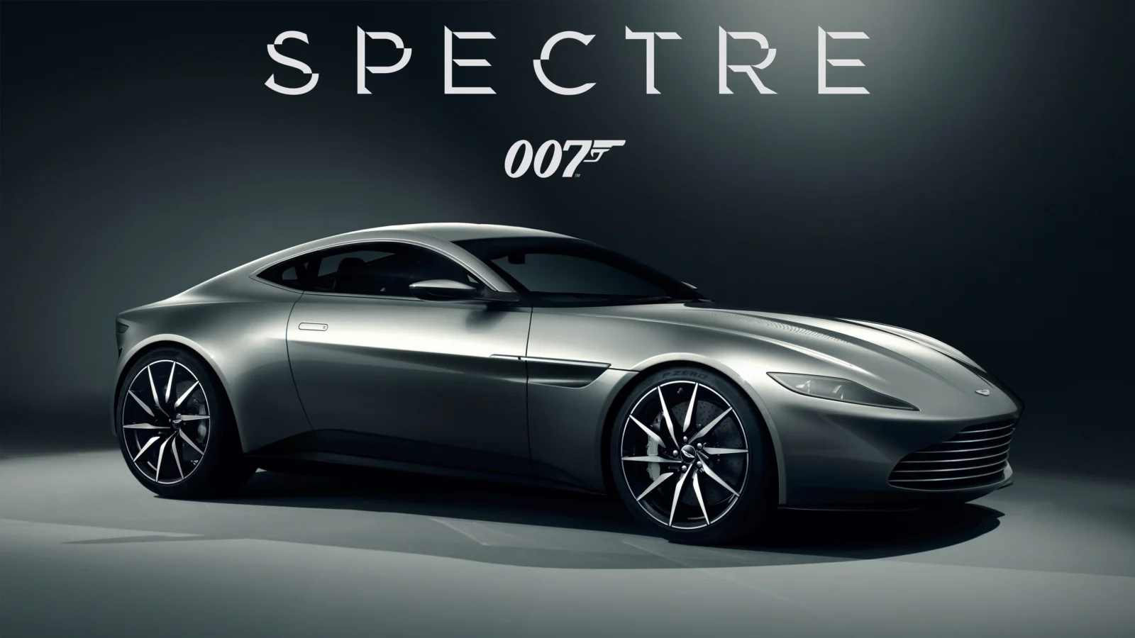 一辆银色跑车停在深色背景前，画面上方可见“SPECTRE”和“007”字样。