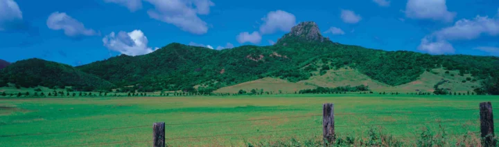 蓝天下的群山、草原与云朵构成开阔的自然全景。