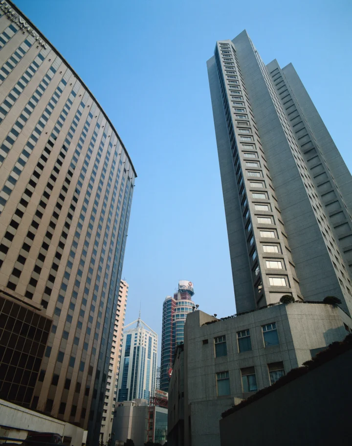 高耸的城市建筑从仰视角度延伸向晴朗的蓝天。