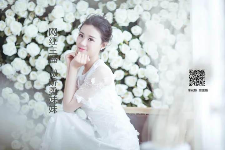 一名身穿白色礼服的女子坐在白玫瑰花墙前，画面右侧有二维码和文字。
