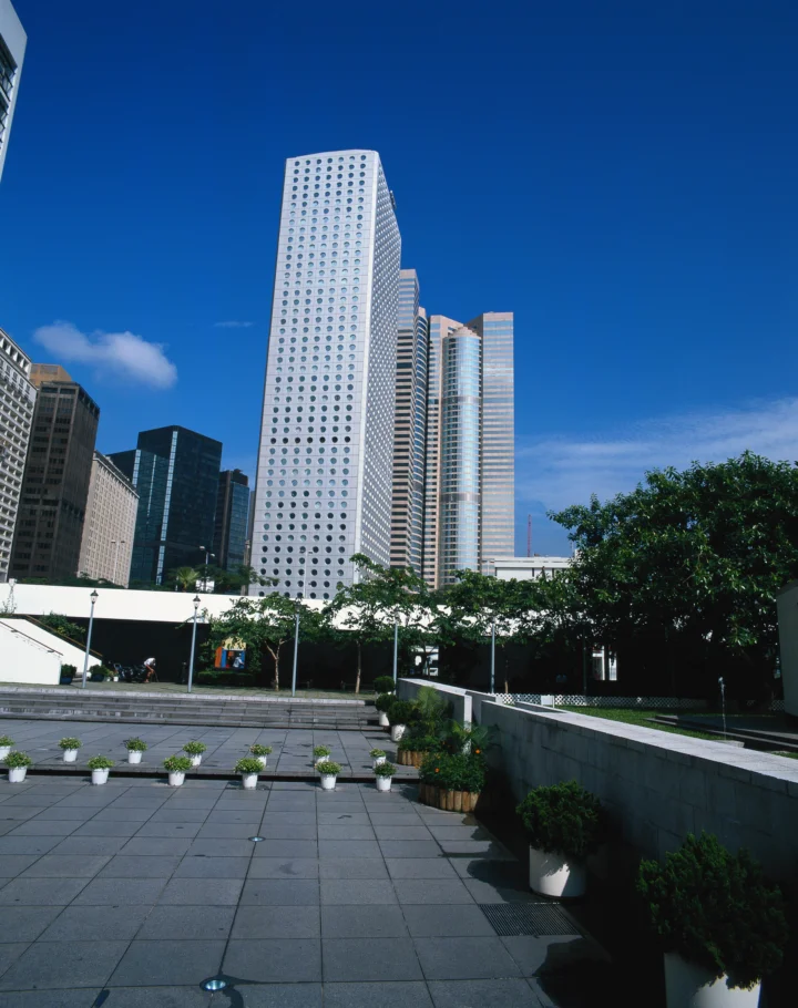 蓝天下，高楼建筑环绕着铺设整齐的城市广场。