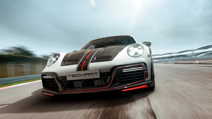 一辆白色跑车正行驶在赛道上，背景因速度产生动态模糊效果。