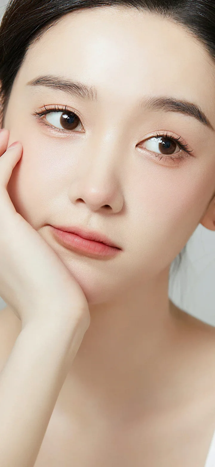 一名成年女性的面部特写，手托脸颊，呈现柔和自然的妆容与表情。