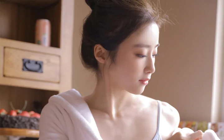 一名成年女性在室内窗边侧脸沐浴在柔和光线中，背景可见木质储物柜。