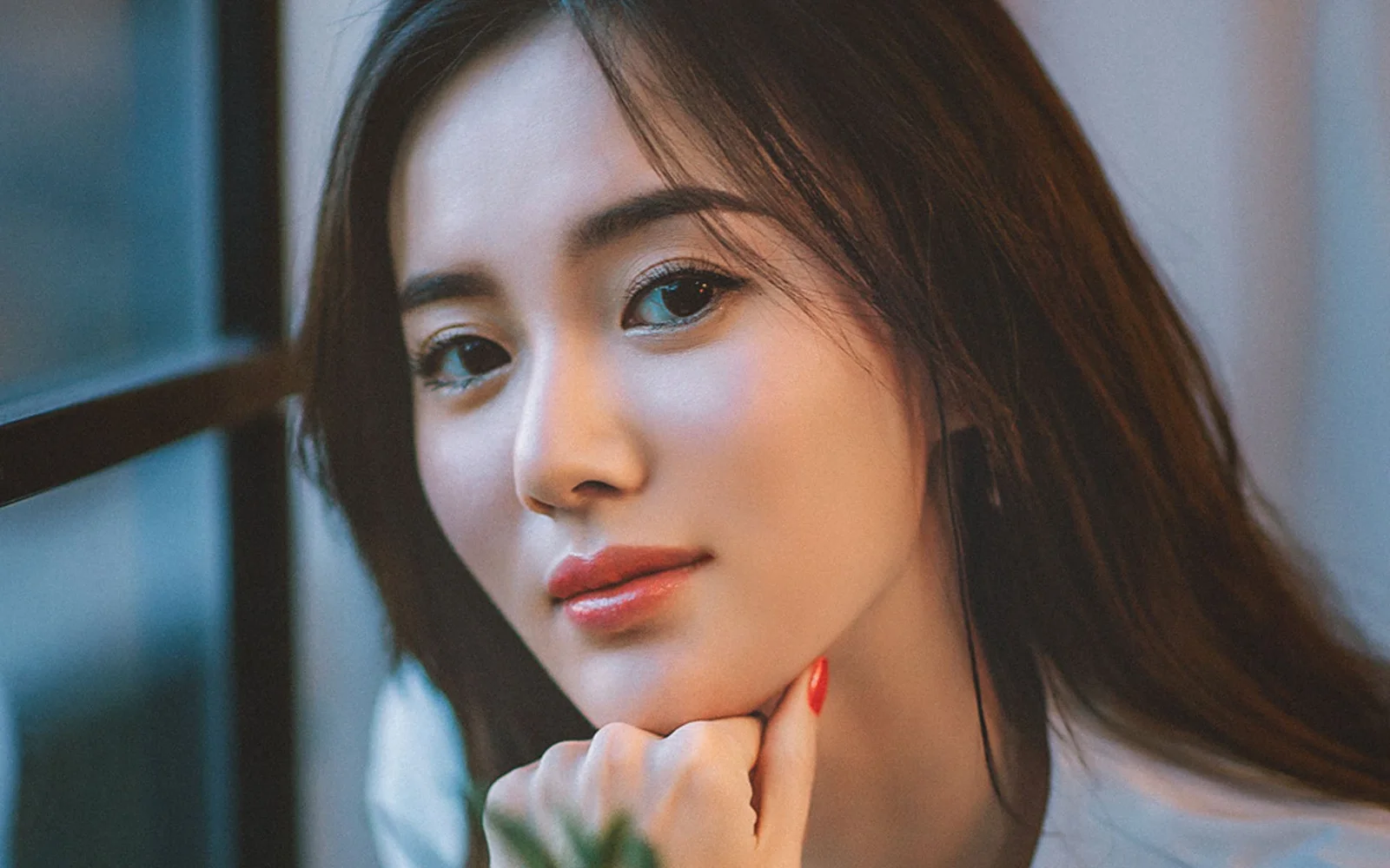 一位长发女性的近距离肖像，面向镜头露出自然表情。