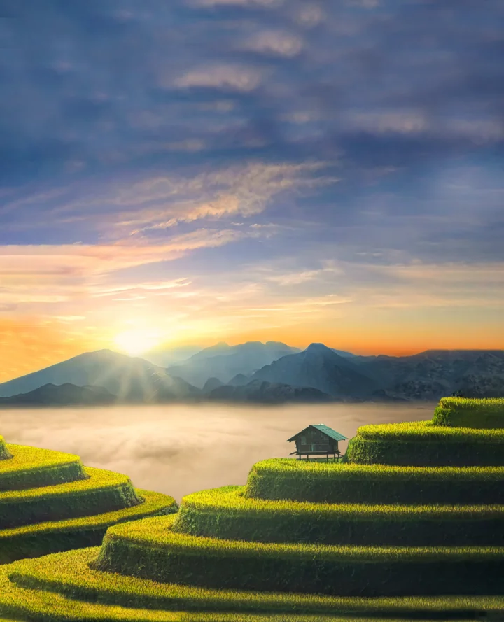 阳光穿透云层照亮群山、云雾和层叠的梯田。