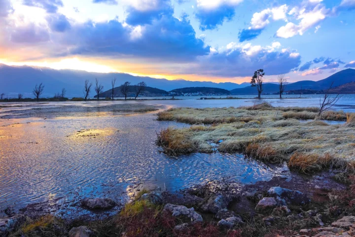 湖水、湿地与远山映照着绚丽的晚霞。