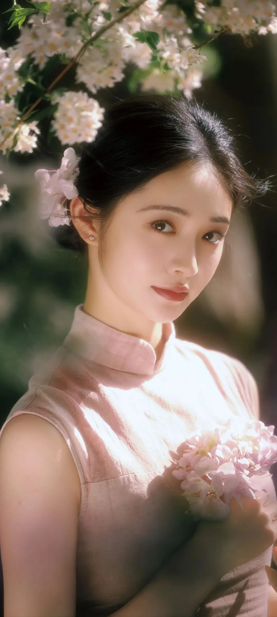 一位身穿粉色服装的成年女子在樱花树下手捧花束。