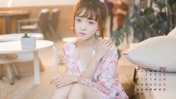 一名成年女性坐在室内空间中，身穿粉色花卉连衣裙，柔和光线映照着她的面容。