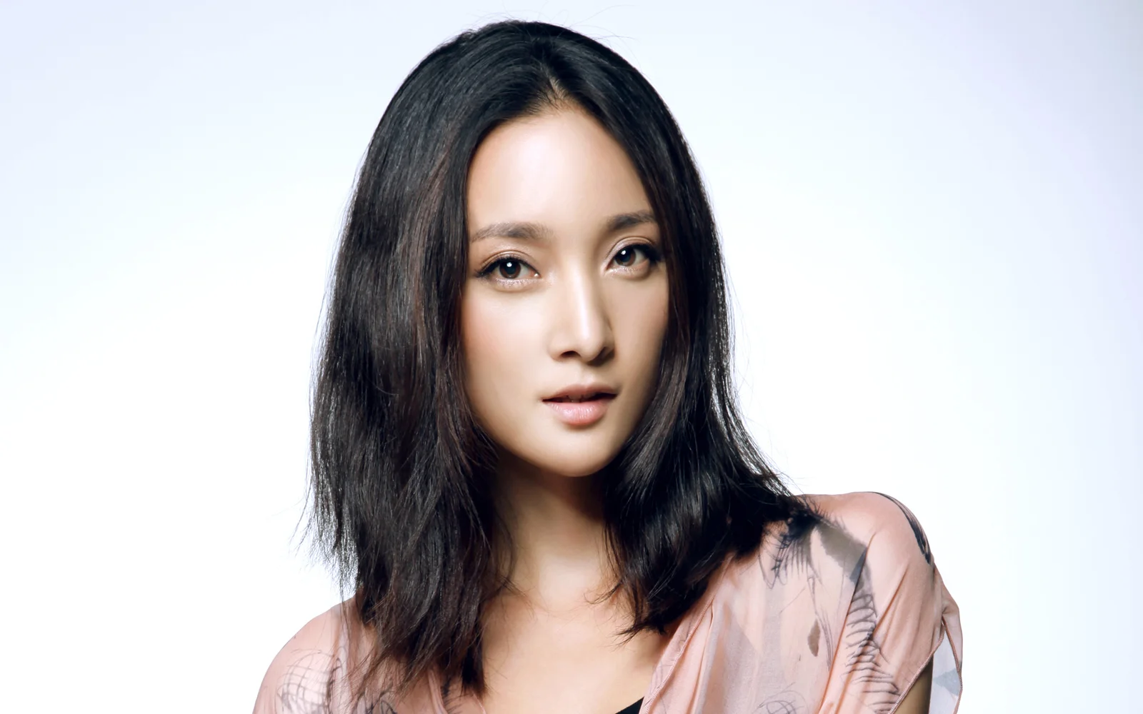 一名黑发女性在明亮的浅色背景前面向镜头。