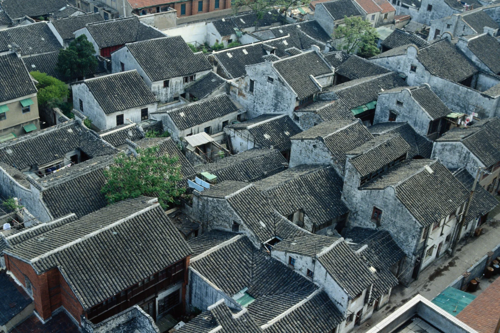 俯瞰一片由灰瓦屋顶和白墙老宅组成的传统古镇建筑群。