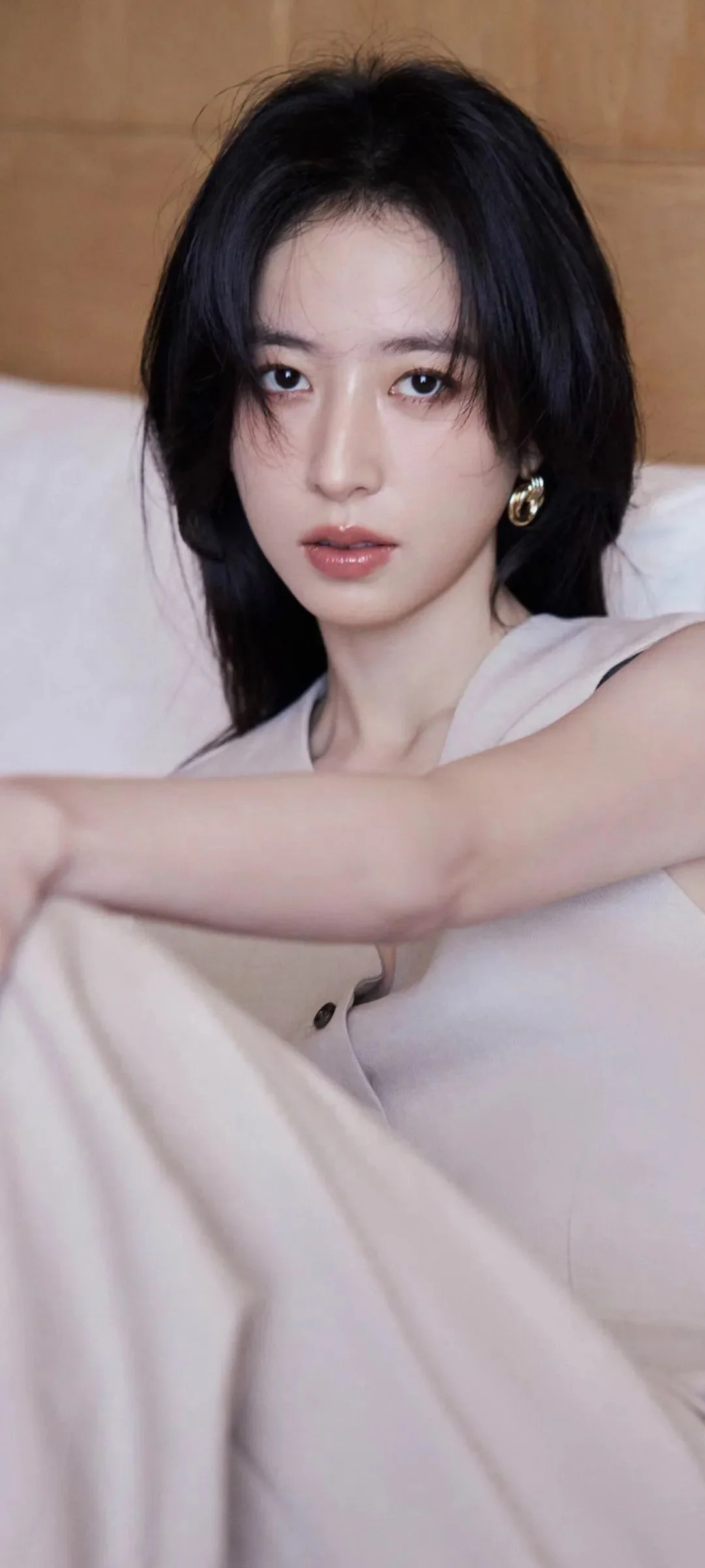 검은 머리의 여성이 밝은 색 상의를 입고 실내에서 카메라를 바라보는 인물 사진입니다.