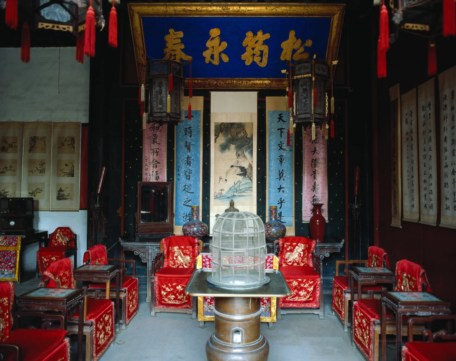 画面展示了古寺内装饰华丽的神龛、红色座椅、书画和悬挂的灯笼。
