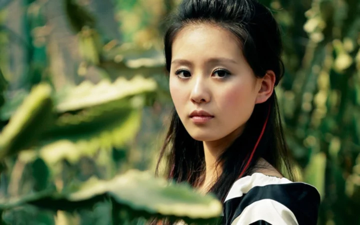 一名女性在绿色森林背景前面对镜头。