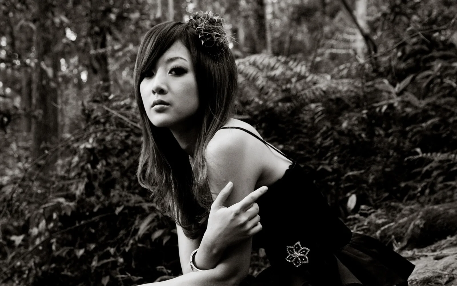 一名女性在黑白森林环境中摆姿势拍摄人像。