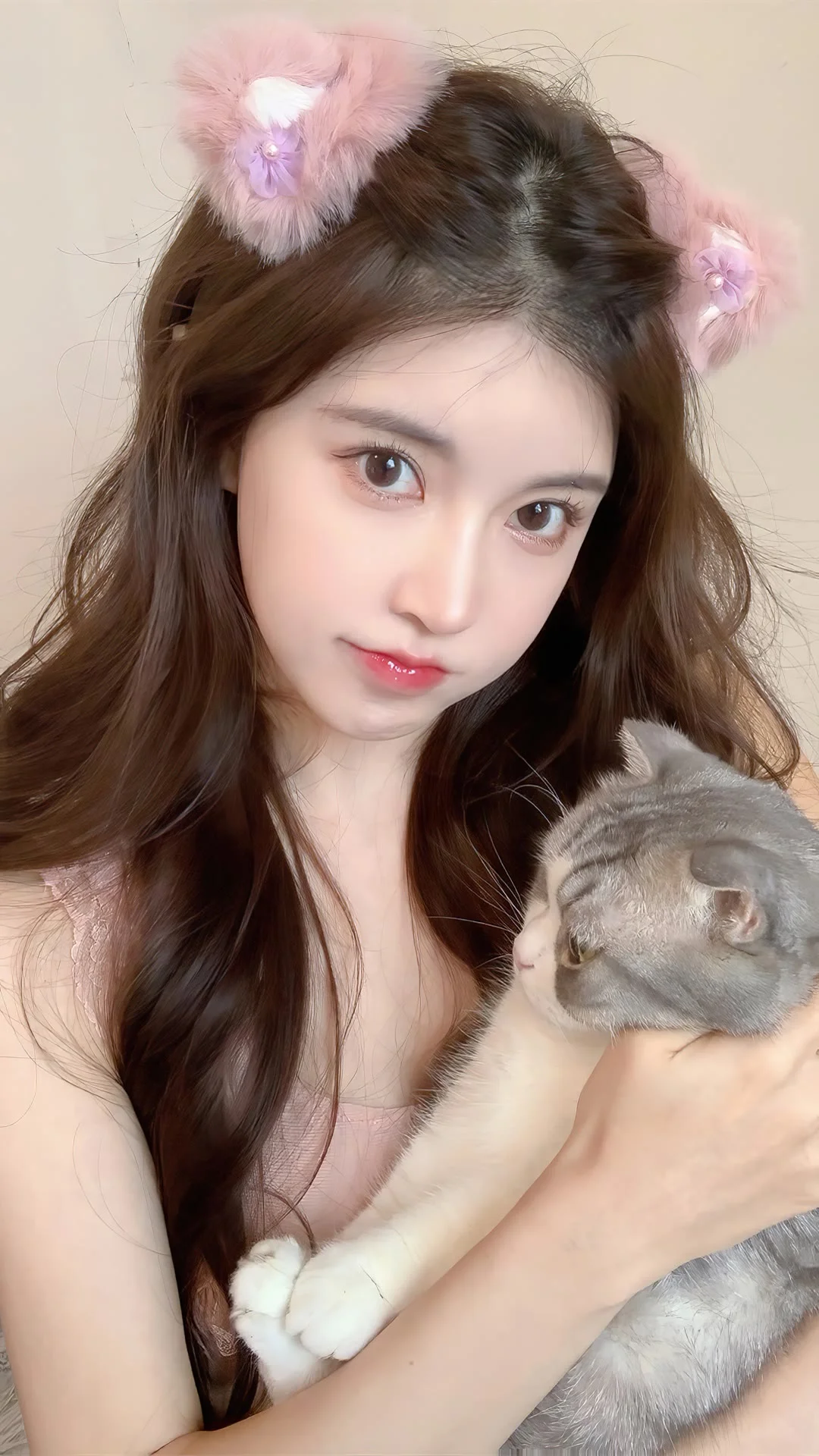 一名长发女性抱着一只灰色猫咪自拍。