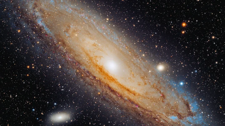 一幅旋涡星系横跨画面并被密集星空环绕的宇宙影像。