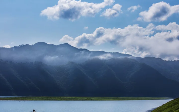 群山、湖泊与云层构成宁静的自然风景。