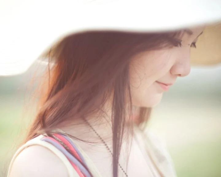 一名长发成年女性在明亮朦胧背景前呈现柔和的侧脸肖像。