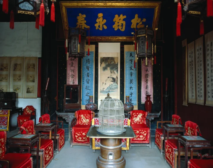 画面展示了古寺内装饰华丽的神龛、红色座椅、书画和悬挂的灯笼。