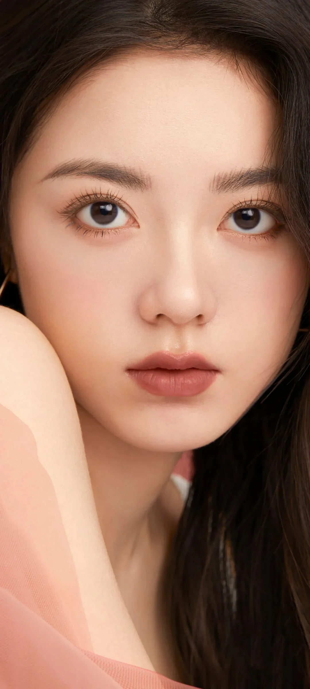 一位长发女性的近距离肖像，面部沐浴在柔和光线中。