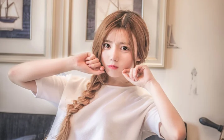 一名成年女性在室内面对镜头摆出轻松姿势。