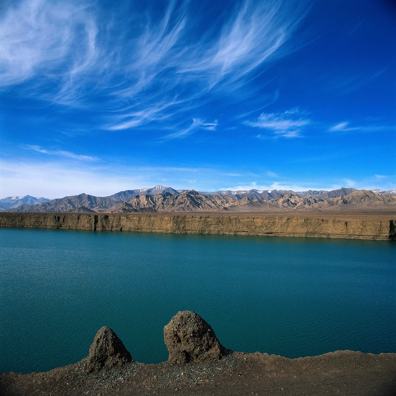 湖水、荒原山脉与高空云层构成宁静的自然风景。