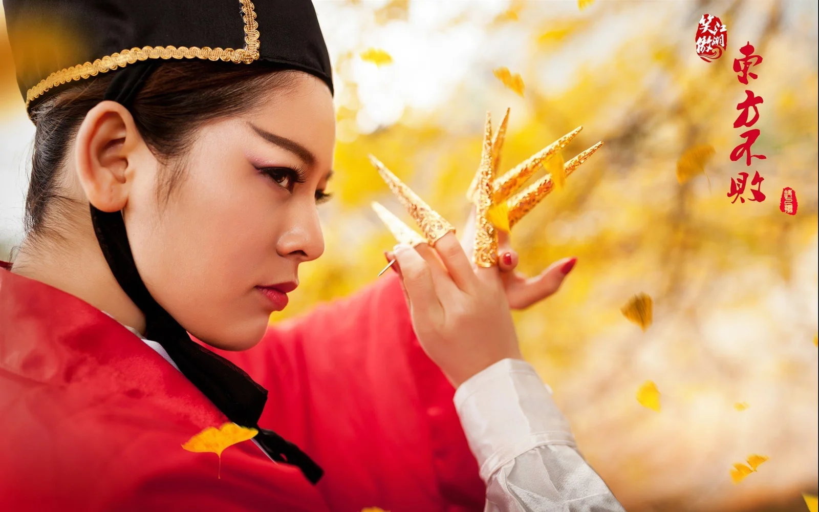 一名身穿红色传统服饰的女子侧身面对镜头，手持金色装饰，背景是虚化的秋日落叶。