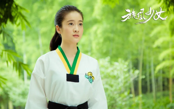 一名身穿白色上衣的女性站在翠绿色竹林中，画面右上方带有白色文字装饰。