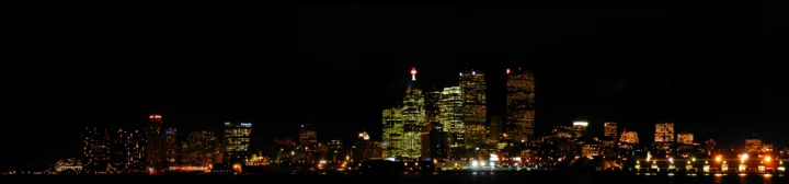 夜幕下的城市天际线被点亮的建筑和街道灯光映照。